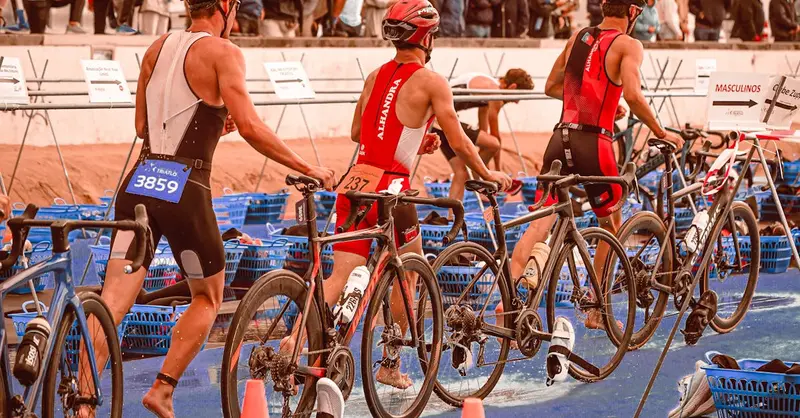 Athletes transition from swimming to cycling at a triathlon event.