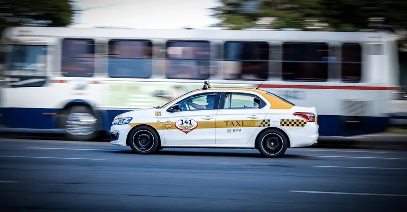 A yellow and white taxi speeding through Montevideo city streets, captured with motion blur effect.