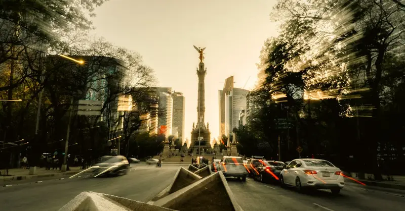 Vibrant cityscape of Angel of Independence in Mexico City with motion blur effects at dusk.