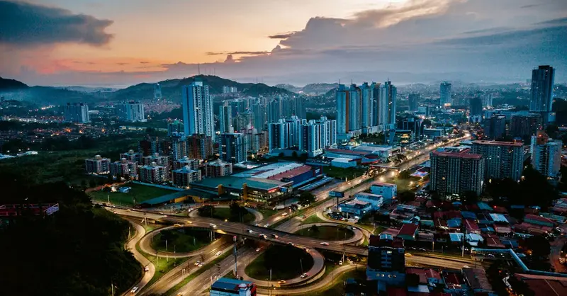 Stunning aerial view of Panama City skyline and roads at sunset, vibrant urban landscape.