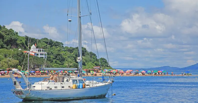 A picturesque sailboat near Taboga Island in Panama with a vibrant summer beach and clear blue sky.