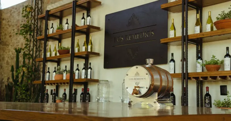 An elegant wine bar interior featuring a decorative barrel and neatly arranged wine bottles on shelves.