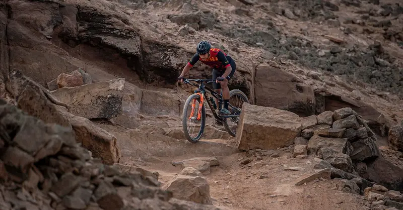Cyclist navigating rocky mountain trail in Peru. Perfect for adventure sport enthusiasts.