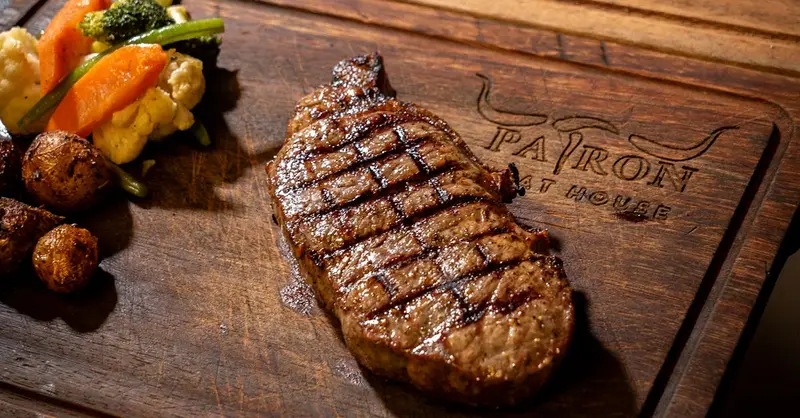 Perfectly grilled steak with vegetables on a rustic wooden board.