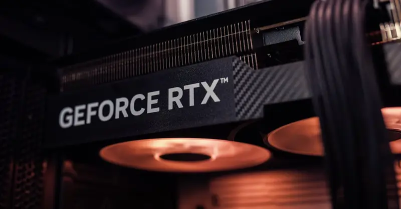 GeForce RTX graphics card installed inside a PC, glowing under warm lighting.