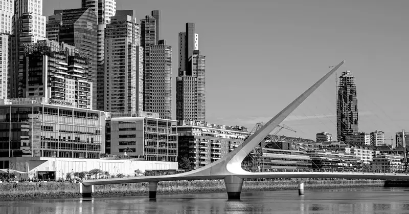 Black and white image of the Puente de la Mujer and Buenos Aires skyline, showcasing modern architecture.