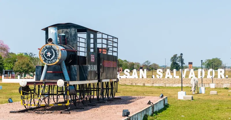 Outdoor exhibit of a vintage train model at San Salvador park with prominent letters.