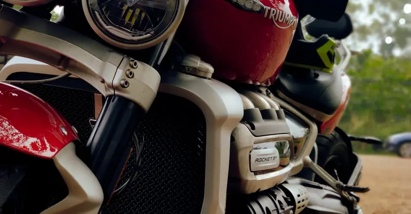 Detailed view of the Triumph Rocket 3 motorcycle engine and headlights, emphasizing design and power.