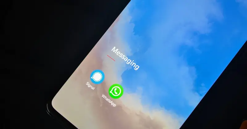 Close-up of smartphone screen showing Signal and WhatsApp messaging apps.