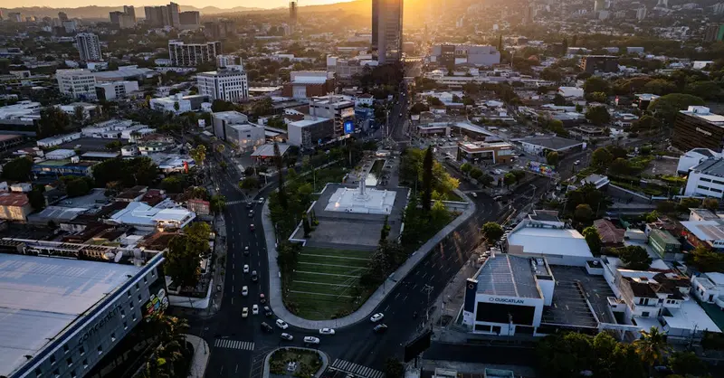 Stunning aerial view of San Salvador cityscape during sunset, showcasing urban landscape and vibrant colors.