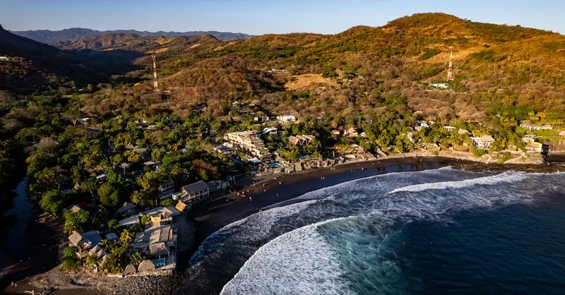 Stunning aerial view of El Zonte Beach, showcasing the coastline and lush hillsides in El Salvador.