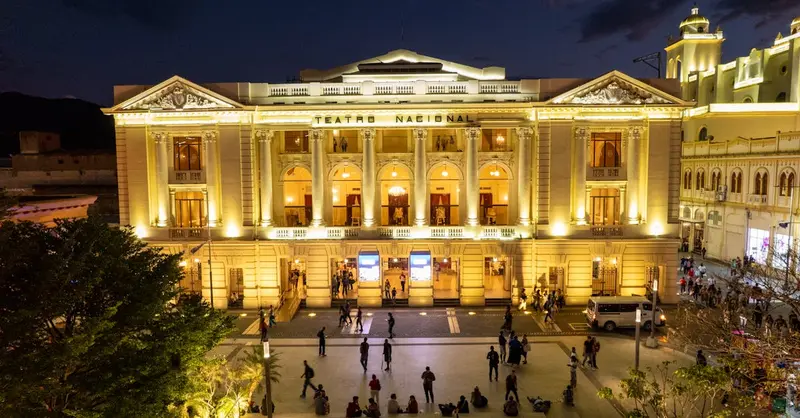 Illuminated Teatro Nacional in San Salvador during night showcasing vibrant city life.