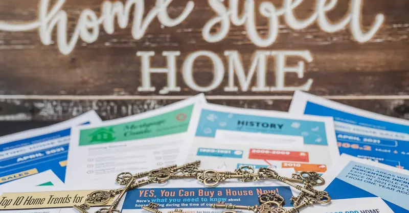 A conceptual image of real estate trends with keys and documents in front of a 'Home Sweet Home' sign.