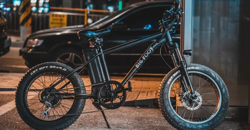A modern e-bike parked by the sidewalk in an urban setting at night, showcasing technology.