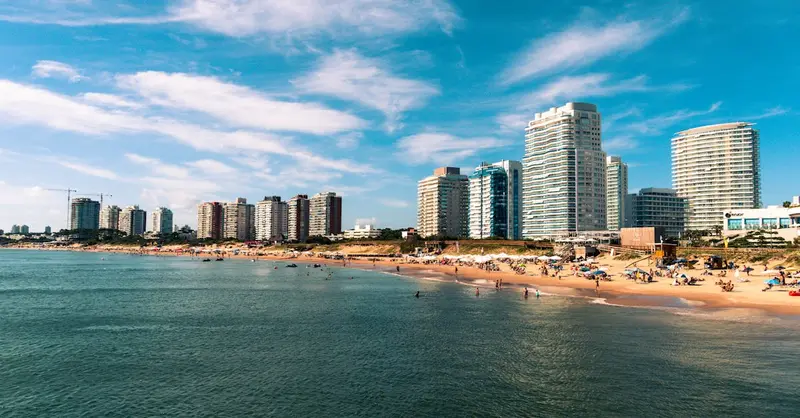 Explore Punta del Este's beautiful beachfront cityscape with blue waters and vibrant life.