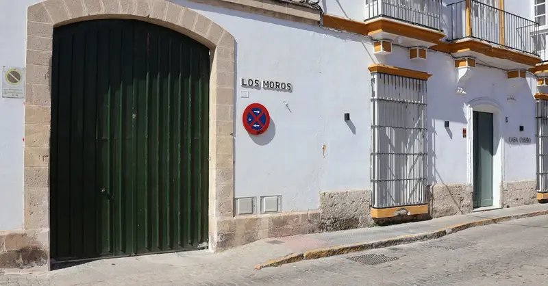 Whitewashed building façade with green door in Andalucía, Spain.