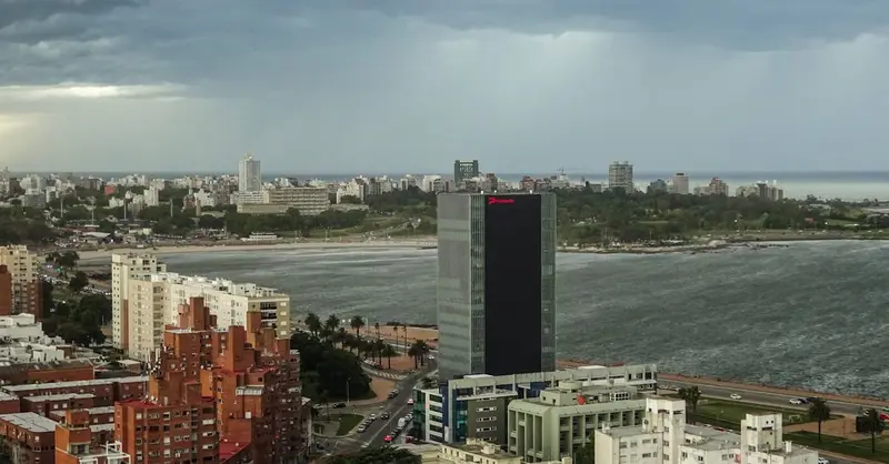 A panoramic view of Montevideo's cityscape with dramatic storm clouds rolling in over the coastline.