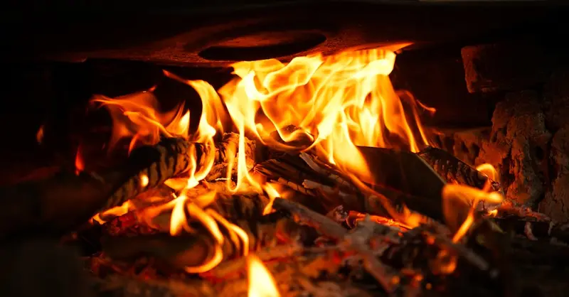 A close-up of vibrant flames engulfing wood, showcasing the warmth and energy of fire.
