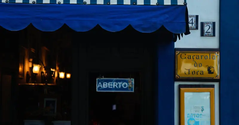 Cozy restaurant entrance with a striped awning in Antonina, Brazil.