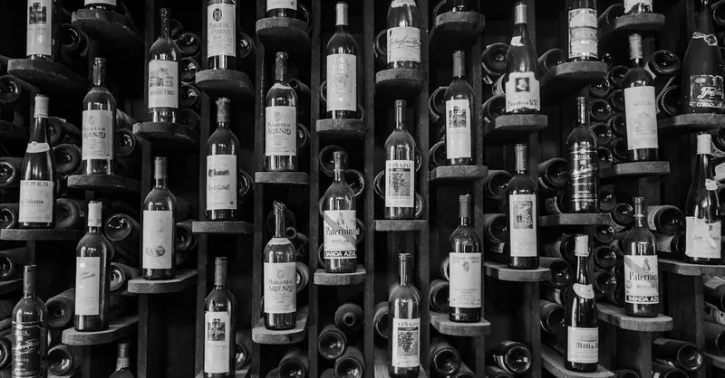 A black and white photo showcasing an elegant wine rack filled with various bottles.