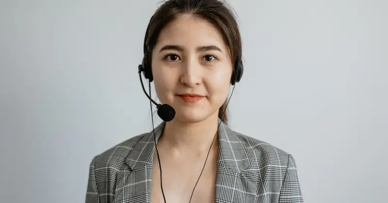 Portrait of a young female call center agent in a professional setting wearing a headset.