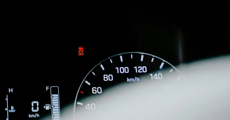 Detailed close-up of a car speedometer displaying a digital reading and warning light.