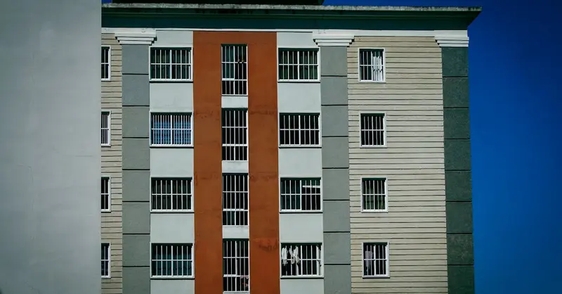 Facade of a modern high-rise building with colorful design against a clear blue sky.