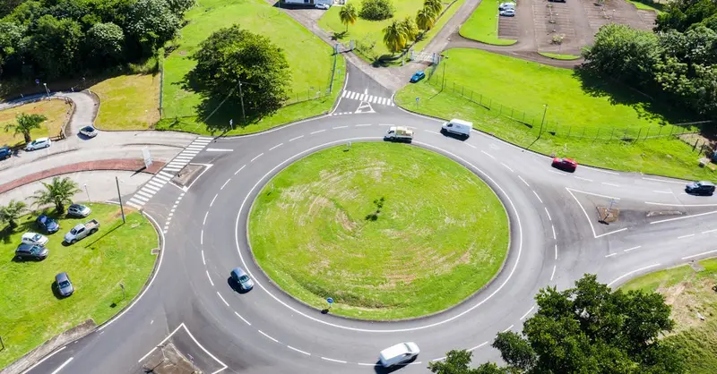 Aerial view of a roundabout surrounded by greenery and buildings in Martinique. Bright day scene.