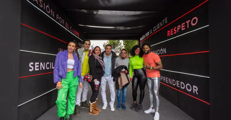 Group of joyful adults enjoying a festive event in Mexico City, showcasing diversity and bright fashion.