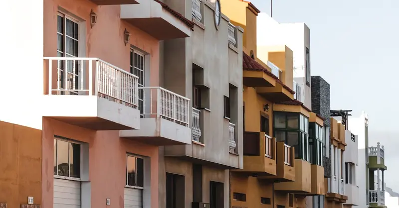 Charming colorful facades of urban residential buildings in a Spanish city, capturing vibrant architecture.
