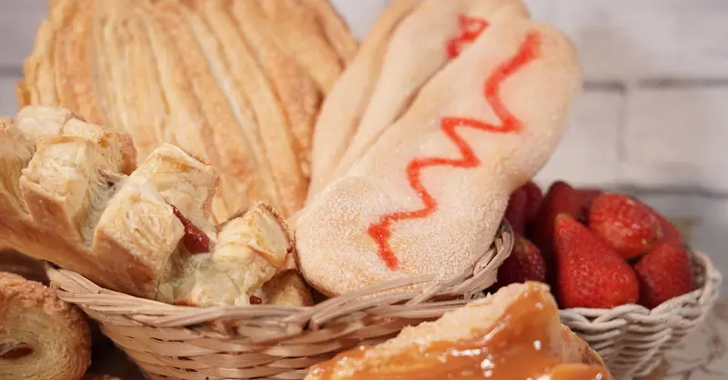 A delicious assortment of pastries including flaky, sugary, and fruit-filled treats in rustic baskets.