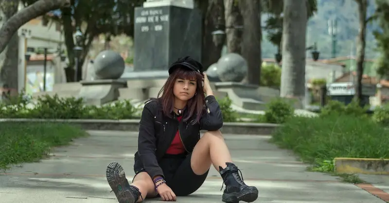 Young woman sitting on pavement in an urban park in Venezuela.